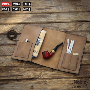 Könnte beinhalten: Geöffnete braune Leder-Tabakpfeifentasche mit roter und schwarzer Pfeife, Feuerzeug und Reinigungszubehör. Die Tasche hat Taschen für Zubehör. Der Schriftzug "Noble Leather Art" befindet sich unten rechts.