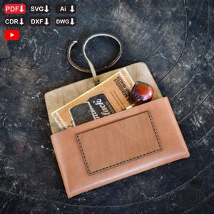 Könnte beinhalten: Eine hellbraune Ledertasche mit einem rechteckigen Aufnäher und einem genähten Rand. Im Inneren sind eine Zigarettenschachtel, ein Feuerzeug und eine kleine Pfeife zu sehen. Oben ist eine Lederschlaufe befestigt. Der Text auf der Zigarettenschachtel lautet "WARNING: SERIOUSLY YOUR HEALTH".