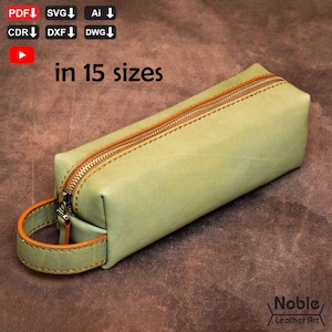 Może przedstawiać: Jasnozielony skórzany piórnik ze złotym zamkiem błyskawicznym i pomarańczowymi szwami. Piórnik ma pasujący uchwyt z pomarańczowymi detalami. Widoczny jest tekst "in 15 sizes". Widoczne jest logo Noble Leather Art.