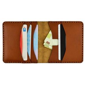 May include: Open brown leather wallet with multiple card slots and a cash pocket. The wallet is filled with various cards and a small amount of cash. The edges are stitched with a contrasting thread.
