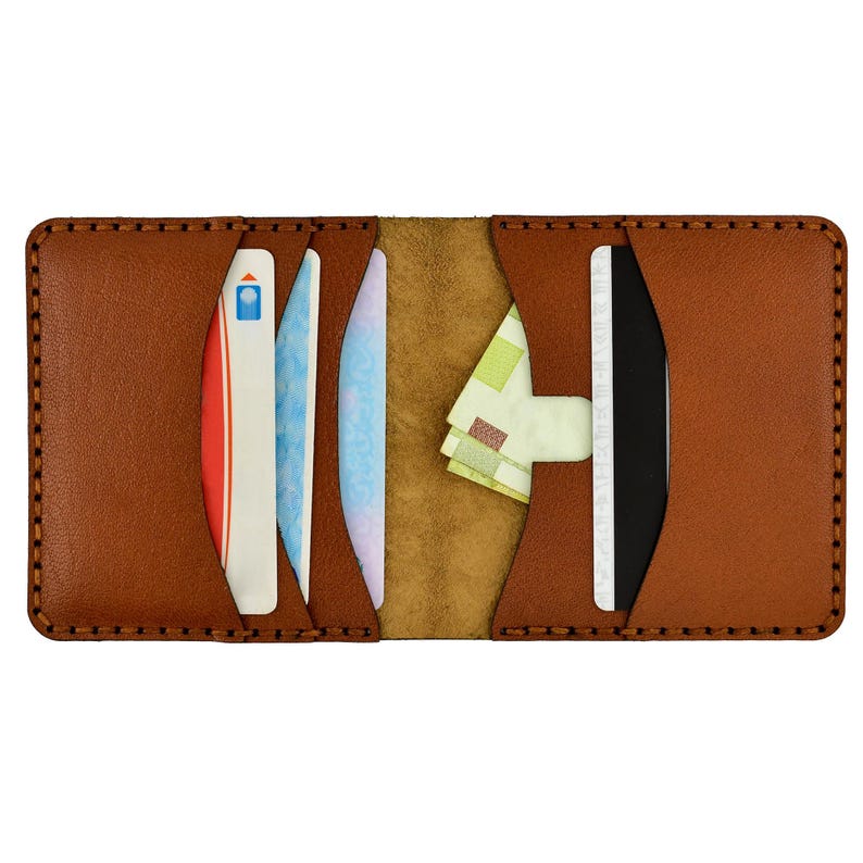 May include: Open brown leather wallet with multiple card slots and a cash pocket. The wallet is filled with various cards and a small amount of cash. The edges are stitched with a contrasting thread.