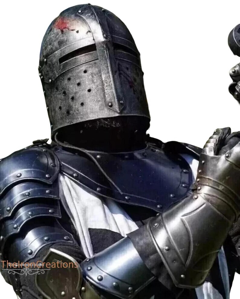 May include: A medieval knight's armor set, featuring a riveted steel helmet with a cross-shaped visor and a matching breastplate and gauntlets. The armor is dark gray with a weathered appearance, and a white and black cross is visible on the chest.