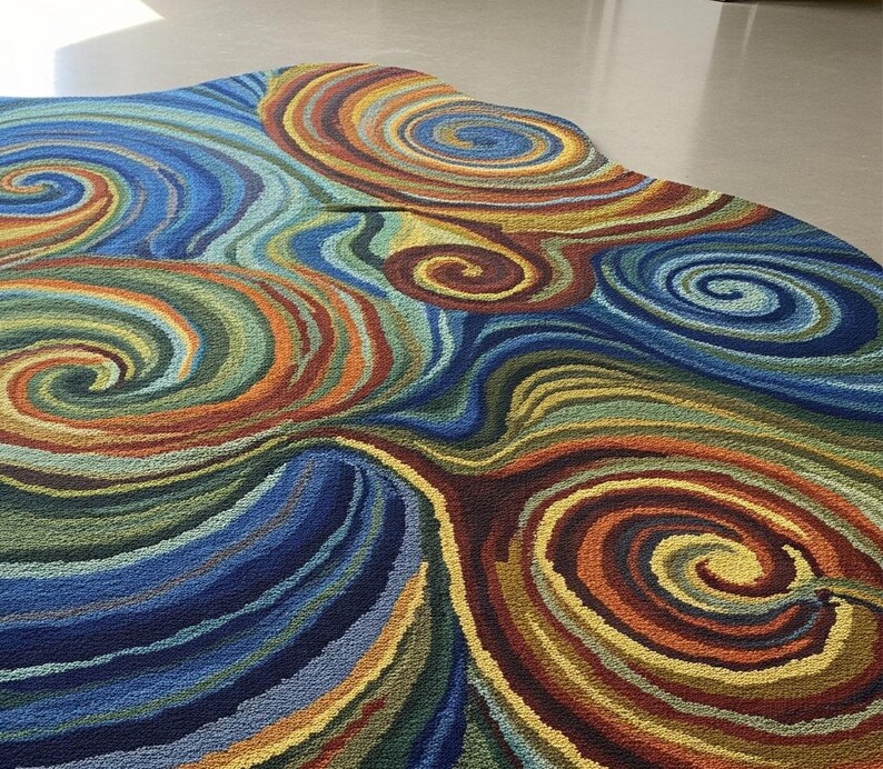 Irregular-shaped area rug featuring vibrant multicolor swirling abstract patterns in blue, green, yellow, red, and orange displayed on a smooth light floor.