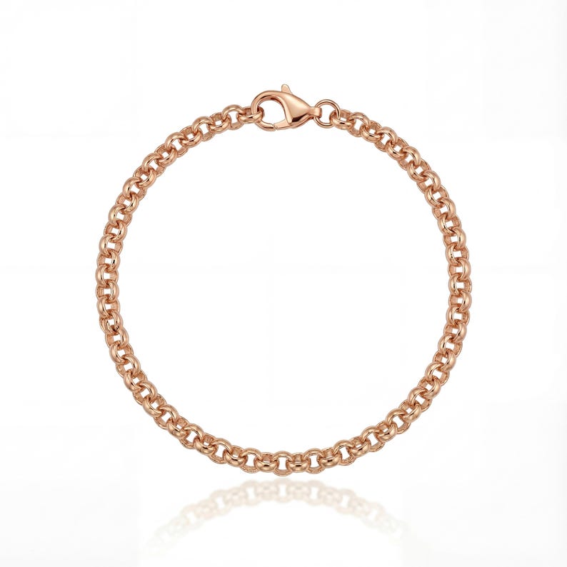 May include: Rose gold chain bracelet with a lobster clasp. The bracelet features a series of interconnected, rounded links. The jewelry is displayed on a white background, with a subtle reflection visible below the bracelet.