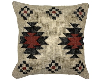 May include: Square beige throw pillow with a geometric pattern. The design features black and rust-colored shapes on a textured background. The pillow has a woven appearance and is likely made of natural fibers.