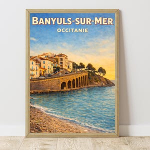 Op de afbeelding: Ingelijste vintage reisaffiche van Banyuls-sur-Mer, Occitanie. Het kunstwerk toont een kustplaats met een stenen brug, gebouwen en de zee. De lucht gaat over van blauw naar geel, wat zonsopgang of zonsondergang suggereert.