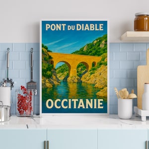 May include: A framed vintage travel poster depicting the Pont du Diable bridge in Occitanie, France. The poster shows a blue sky, a yellow bridge, and green foliage. The text "PONT DU DIABLE" and "OCCITANIE" are displayed in white and beige.
