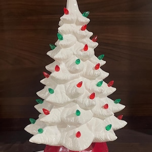 以下が含まれることがあります： 白のセラミッククリスマスツリー、赤いベース、赤と緑のライト。 クラシックなホリデーデコレーションで、どんな家にもお祝いの雰囲気を加えるのに最適です。
