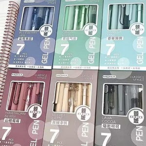 May include: Six rectangular boxes of Moka brand gel pens, each containing 7 pieces. The sets are labeled Blueberry Jam, Qingti Bubble, Vanilla Mint, Hawthorn Berry, Velvet Latte, and Lava Cocoa, featuring various pastel and neutral color themes.