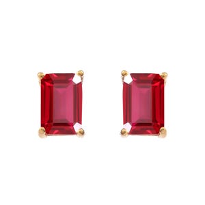 Puede incluir: Un par de pendientes de botón con piedras preciosas rojas de corte esmeralda rectangular engastadas en garras de metal dorado. Cada piedra roja vibrante muestra facetas claras que reflejan la luz, sujetas por cuatro pequeñas garras doradas.