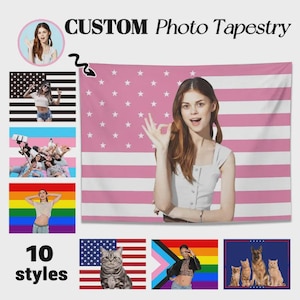 Op de afbeelding: Een aangepaste fototapestry met een roze en wit Amerikaans vlagontwerp. De afbeelding bevat een vrouw die een 'oké' handgebaar maakt. Extra ontwerpen zijn onder meer een zwart-wit Amerikaanse vlag, een regenboogvlag en een kat met een Amerikaanse vlag.