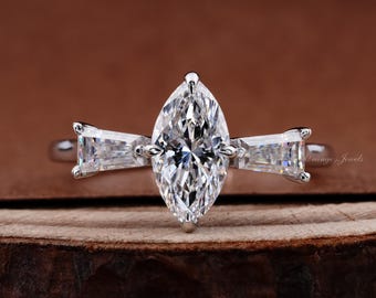 Anillo de tres piedras con diamante cultivado en laboratorio, talla marquesa de 1 quilate, y diamantes laterales talla baguette cónicos.
