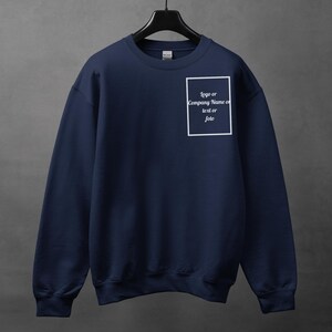 Może przedstawiać: Granatowa bluza z okrągłym dekoltem, zawieszona na czarnym wieszaku. Na piersi biały prostokąt z napisem "logo or Company Name or text or foto". Bluza wykonana jest z miękkiego materiału.