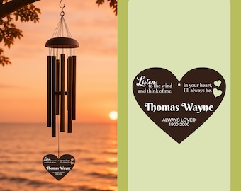 May include: A dark brown wind chime hanging from a tree branch against a sunset backdrop. The chime has several cylindrical tubes and a heart-shaped pendant with the text "Listen to the wind and think of me." The pendant also includes the name "Thomas Wayne" and dates.