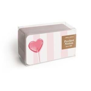 May include: A clear plastic box containing a stack of rectangular pocket notes. The front label features a pink heart-shaped lollipop graphic against a white and light pink striped background, with the text INKLINGS Pocket Notes Set of 50.