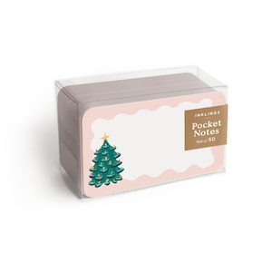 Puede incluir: Un juego de notas de bolsillo en una caja transparente. Las notas tienen un borde rosa, un centro blanco y una ilustración de árbol de Navidad verde. La etiqueta dice "INKLINGS Pocket Notes Set of 50."
