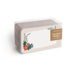 Könnte beinhalten: Ein Set aus 50 Notizkarten in einer transparenten Kunststoffbox. Die Karten haben einen cremefarbenen Hintergrund mit einer weihnachtlichen Illustration aus roten Weihnachtssternen, grünen Stechpalmenblättern und Zweigen. Ein braunes Etikett trägt INKLINGS.