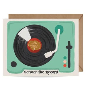 Könnte beinhalten: Grußkarte mit einem Retro-Plattenspieler-Design. Die Karte zeigt eine schwarze Schallplatte mit dem Text "You are an absolute legend". Die Karte ist mintgrün mit den Worten "Scratch the Record" am unteren Rand.