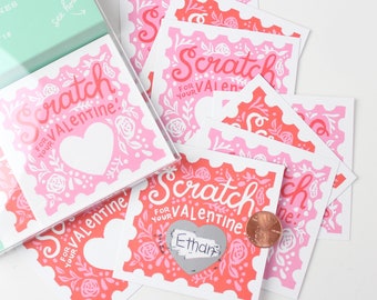 Puede incluir: Un montón de tarjetas de rascar de color rosa y rojo con el texto "Scratch for your Valentine" y una forma de corazón. Las tarjetas están decoradas con diseños florales.