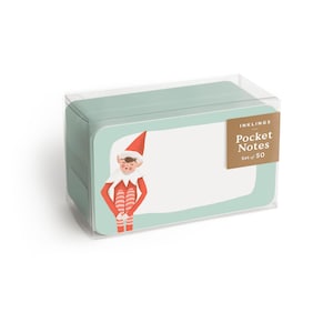 Puede incluir: Una caja de 50 notas de bolsillo con temática de duendes. Las notas son de color azul claro con un borde blanco y presentan una ilustración de un duende con un traje rojo y blanco. La caja tiene una etiqueta dorada que dice "Inkling's Pocket Notes Set of 50".