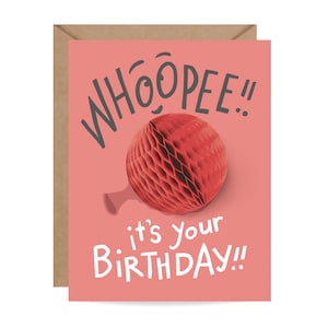 Può includere: Biglietto di auguri di compleanno con sfondo corallo e busta marrone. La carta presenta il testo "WHOOPEE!!" in grigio e "it's your BIRTHDAY!!" in bianco. Una palla a nido d'ape rossa al centro.