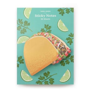 Pode incluir: Um bloco de notas autocolantes com um design de taco. O bloco de notas tem um fundo azul-turquesa com fatias de limão e raminhos de coentro. O taco é amarelo e recheado com ingredientes coloridos. O texto "INKLINGS Sticky Notes 50 Sheets" está impresso no topo.