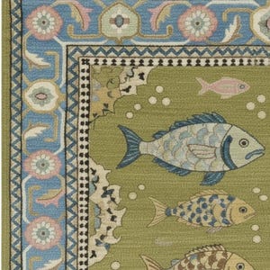 May include: A detailed close-up of a green rug with a fish pattern. The rug features a border with blue and pink floral designs. The main field of the rug has several fish in shades of blue, yellow, and brown, with white bubbles.