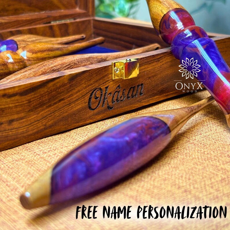 May include: Wooden box with the name "Okasan" engraved on the front. The box contains wooden tools with purple and red accents. The text "FREE NAME PERSONALIZATION" is at the bottom. The logo "ONYX WOOD" is on the right.