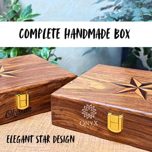 May include: Two handcrafted wooden boxes with star designs inlaid on the lids. The boxes are brown with gold-colored clasps and the text "COMPLETE HANDMADE BOX" and "ELEGANT STAR DESIGN". One box has the name "Okasan" engraved.