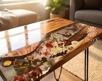 May include: A handcrafted coffee table with a clear resin center filled with colorful dried flowers. The table has a natural wood border and black hairpin legs. The Onyx Wood logo is visible on the table's surface.
