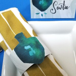 Décorations de table Dreidel pour Hanukkah - Anneau de serviette de Hanukah imprimable et décor de table de carte de place avec l'art de l'aquarelle