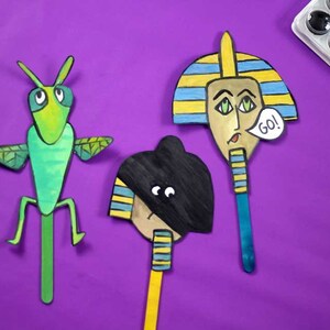 May include: Three stick puppets, one green grasshopper, one black and yellow pharaoh, and one black pharaoh with a blue stick. The pharaohs have yellow and blue striped headdresses. The pharaohs have speech bubbles, one says "GO!"