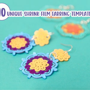 May include: A pair of colorful shrink film earrings with a layered design. The earrings are blue, yellow, and purple and feature a floral pattern. The earrings are hanging from silver earring hooks.
