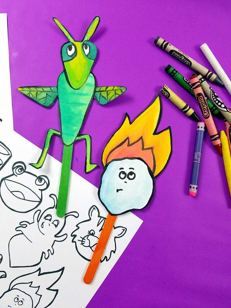 May include: A green grasshopper puppet with large eyes and wings, and a blue and white fire puppet with a stick attached to the bottom. Both puppets are on a white sheet of paper with black and white drawings of animals.