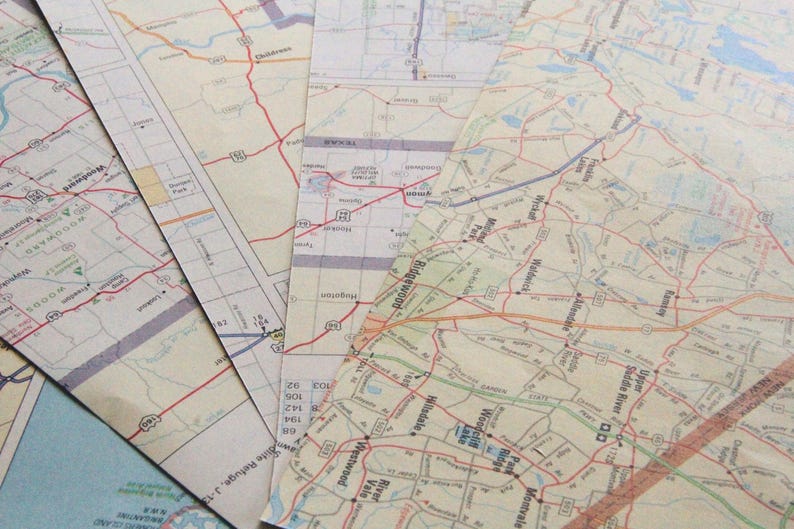 May include: A selection of old road maps, spread out to show their detailed routes and place names. The maps feature a mix of colours, with red lines highlighting roads and highways, and various text labels.