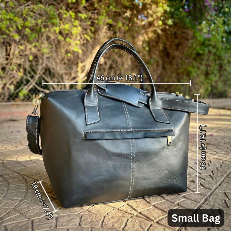 May include: A black leather small bag with white stitching, a top handle, and a shoulder strap. The bag is approximately 46 cm wide, 36 cm high, and 19 cm deep. The bag has a zipper pocket on the front and the text "Small Bag".