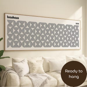 May include: A framed Bauhaus print with a geometric design of black and white semi-circles. The word "Bauhaus" is at the top left, with "1919" on the right. The artwork is ready to hang.