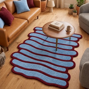 May include: A rectangular area rug featuring a repeating pattern of wavy, light blue horizontal stripes separated by thick, dark burgundy borders, with a soft, tufted texture and rounded, organic edges throughout the design.