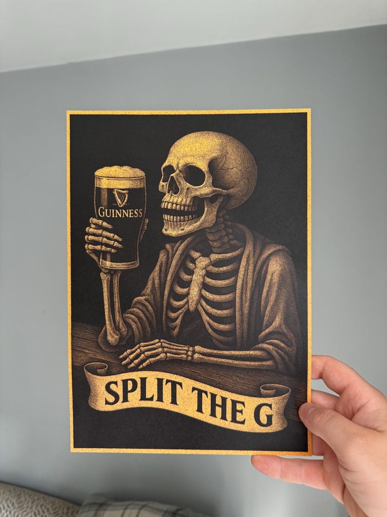 K&ouml;nnte beinhalten: Illustration eines Skeletts, das ein Pint Guinness h&auml;lt. Das Kunstwerk zeigt ein Skelett mit einem Bierglas. Der Text "SPLIT THE G" befindet sich auf einem Banner unter dem Skelett. Schwarzer Hintergrund.