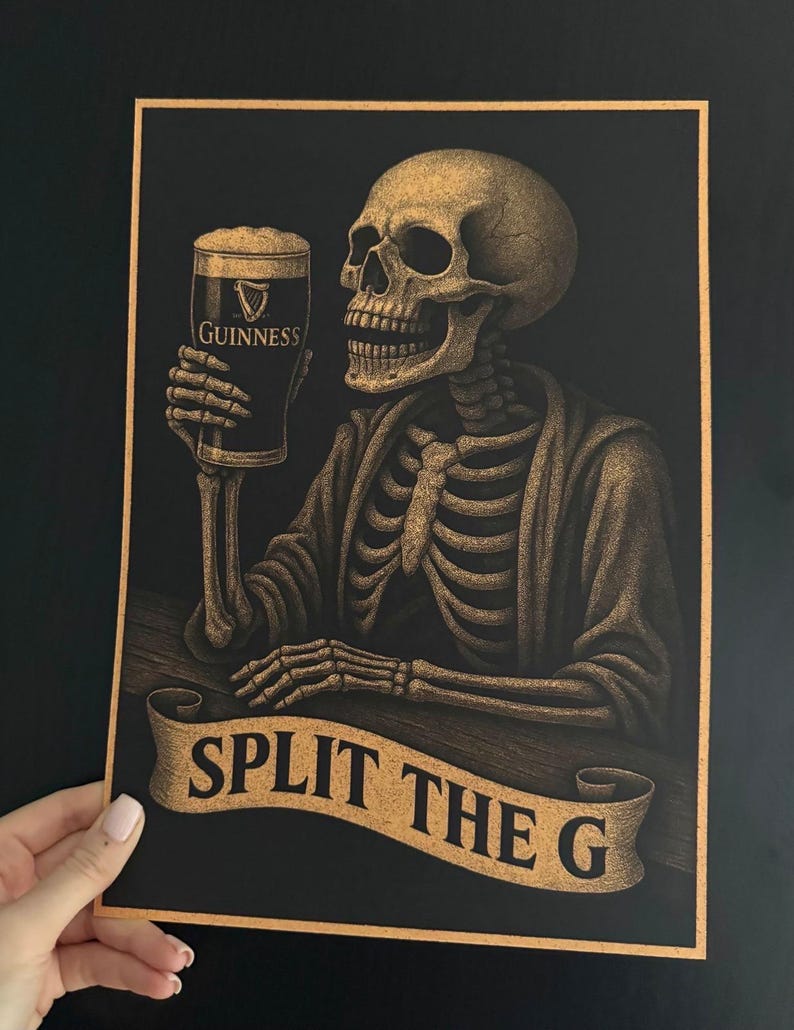 K&ouml;nnte beinhalten: Ein schwarz-goldener Druck, der ein Skelett mit einem Pint Guinness zeigt. Das Skelett sitzt an einer Bar, darunter ein Banner mit der Aufschrift "SPLIT THE G". Das Guinness-Glas ist mit dem Logo der Marke versehen.