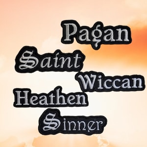 May include: Five embroidered patches with different words on them. The words are "Pagan", "Saint", "Wiccan", "Heathen", and "Sinner". The patches are all black with white lettering.