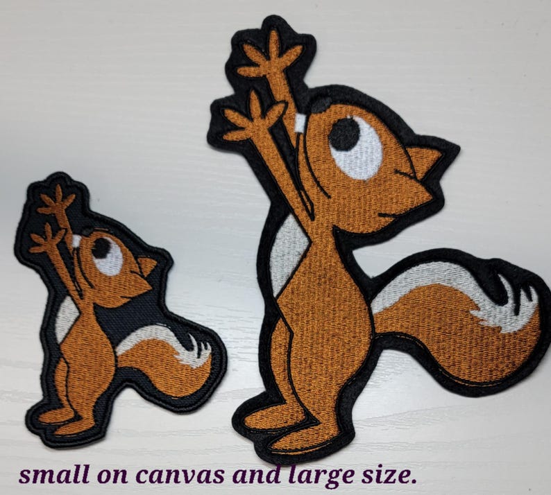 Peut inclure: Deux patchs brod&eacute;s thermocollants repr&eacute;sentant un &eacute;cureuil de dessin anim&eacute; dans un sch&eacute;ma de couleurs brun et blanc. Le plus grand patch mesure environ 7,5 cm de haut et le plus petit environ 5 cm de haut.