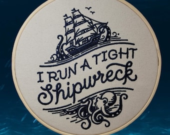 May include: Embroidered hoop art with a black and white design of a ship being pulled down by an octopus with the text "I run a tight shipwreck".