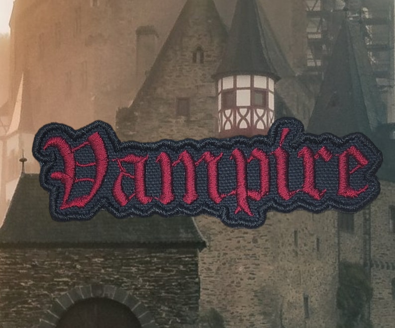 May include: A red embroidered patch with the word "Vampire" in a gothic font on a black background.