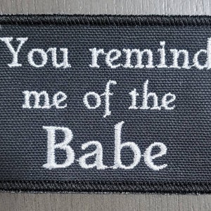May include: Black fabric patch with white embroidered text that reads "You remind me of the Babe".