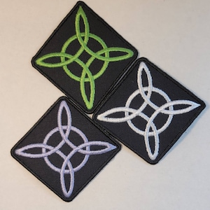 May include: Three embroidered patches with a Celtic knot design. The patches are square and have a black background. The knots are in green, white, and light purple.