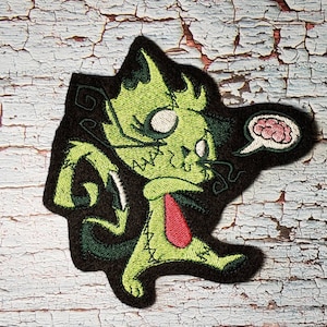 May include: Green stitched monster cat with a red tie and a thought bubble with a pink brain inside. The monster cat is walking and has a stitched-up appearance.
