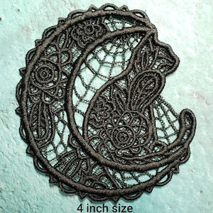 May include: Black lace applique featuring a crescent moon and floral design. The applique is 4 inches in size.