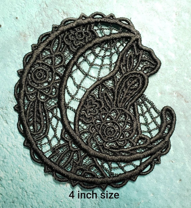 May include: Black lace applique featuring a crescent moon and floral design. The applique is 4 inches in size.