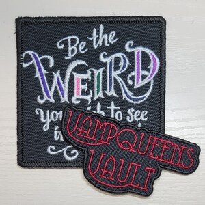 Op de afbeelding: Zwarte en witte geborduurde patch met de tekst "Be the weird you wish to see in the world" en een rode geborduurde patch met de tekst "VampQueens Vault".